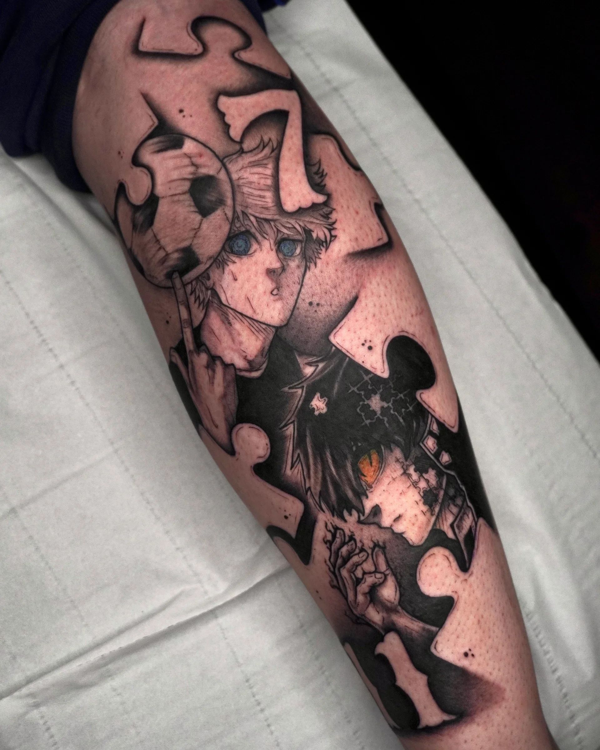 Personajes de anime entre piezas de puzle, con un balón, en el antebrazo