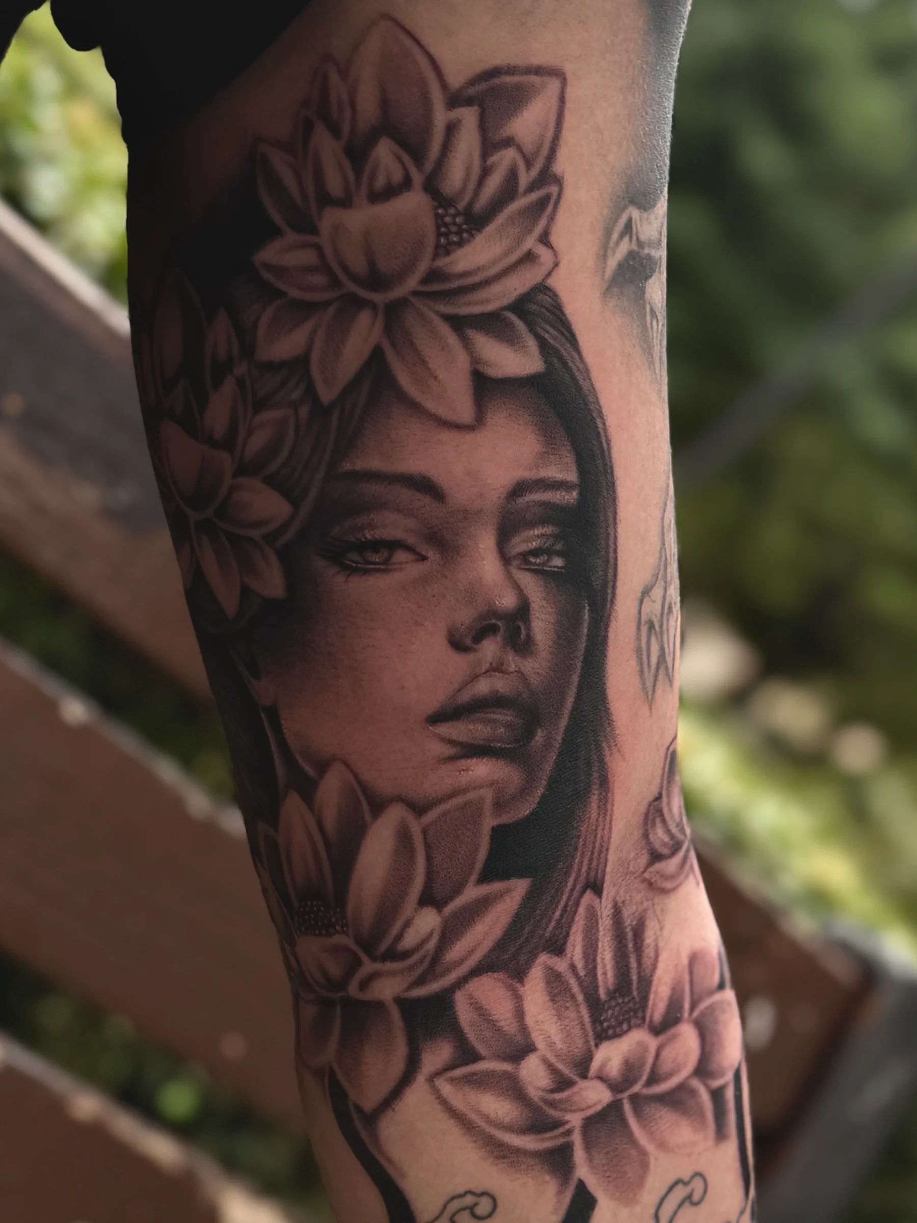 Rostro de mujer con flores de loto en el antebrazo