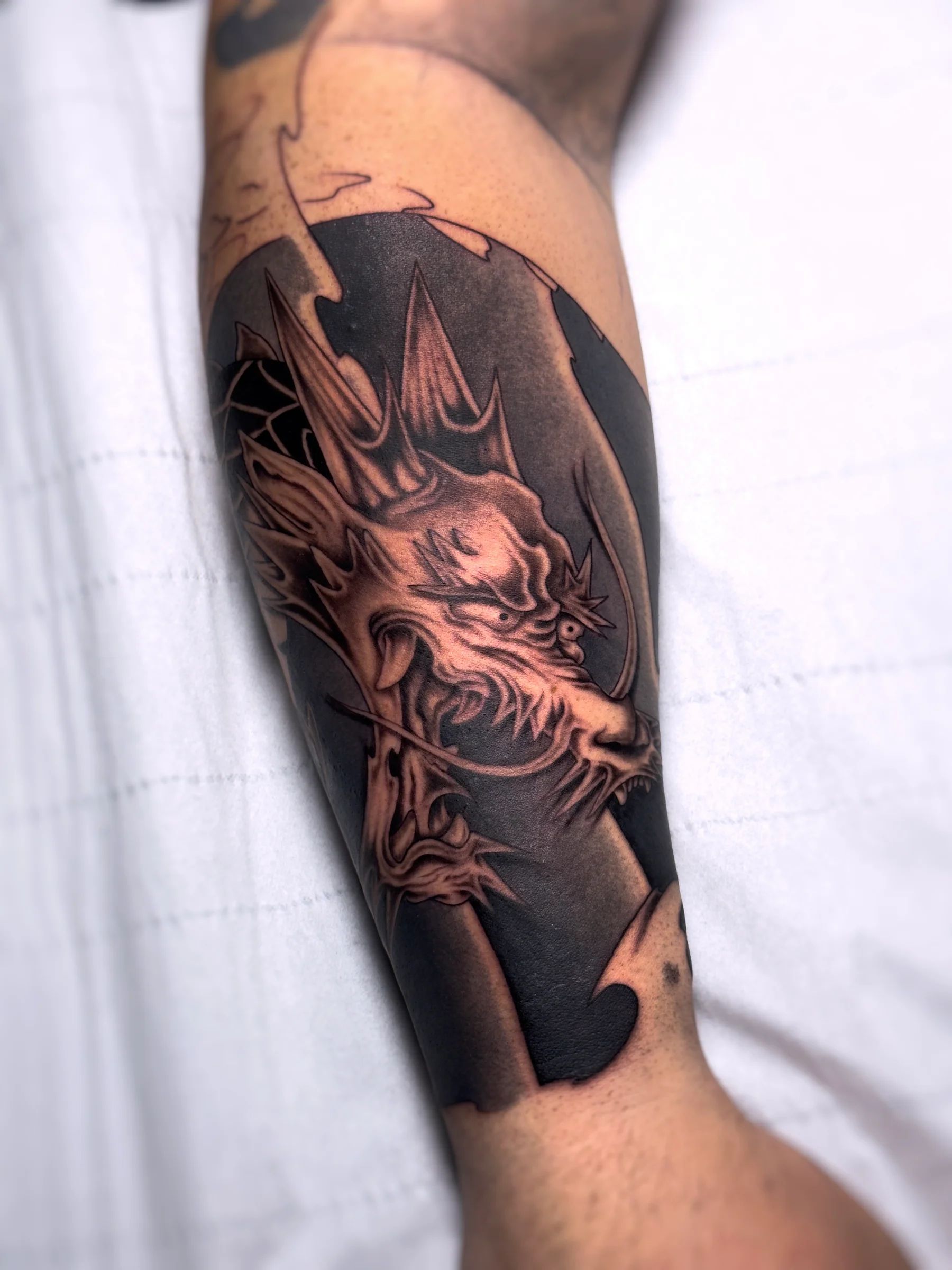 Dragón sobre fondo negro en el antebrazo