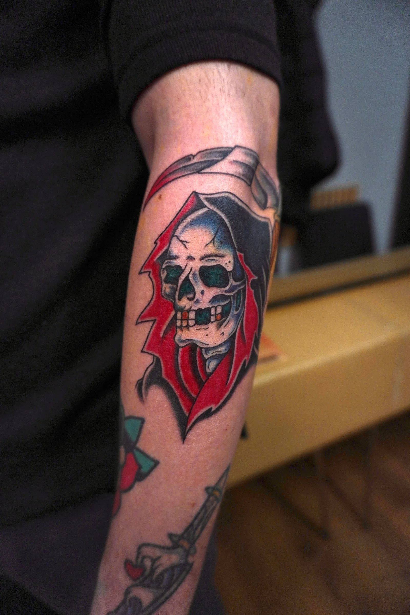 Calavera con capucha roja en el antebrazo