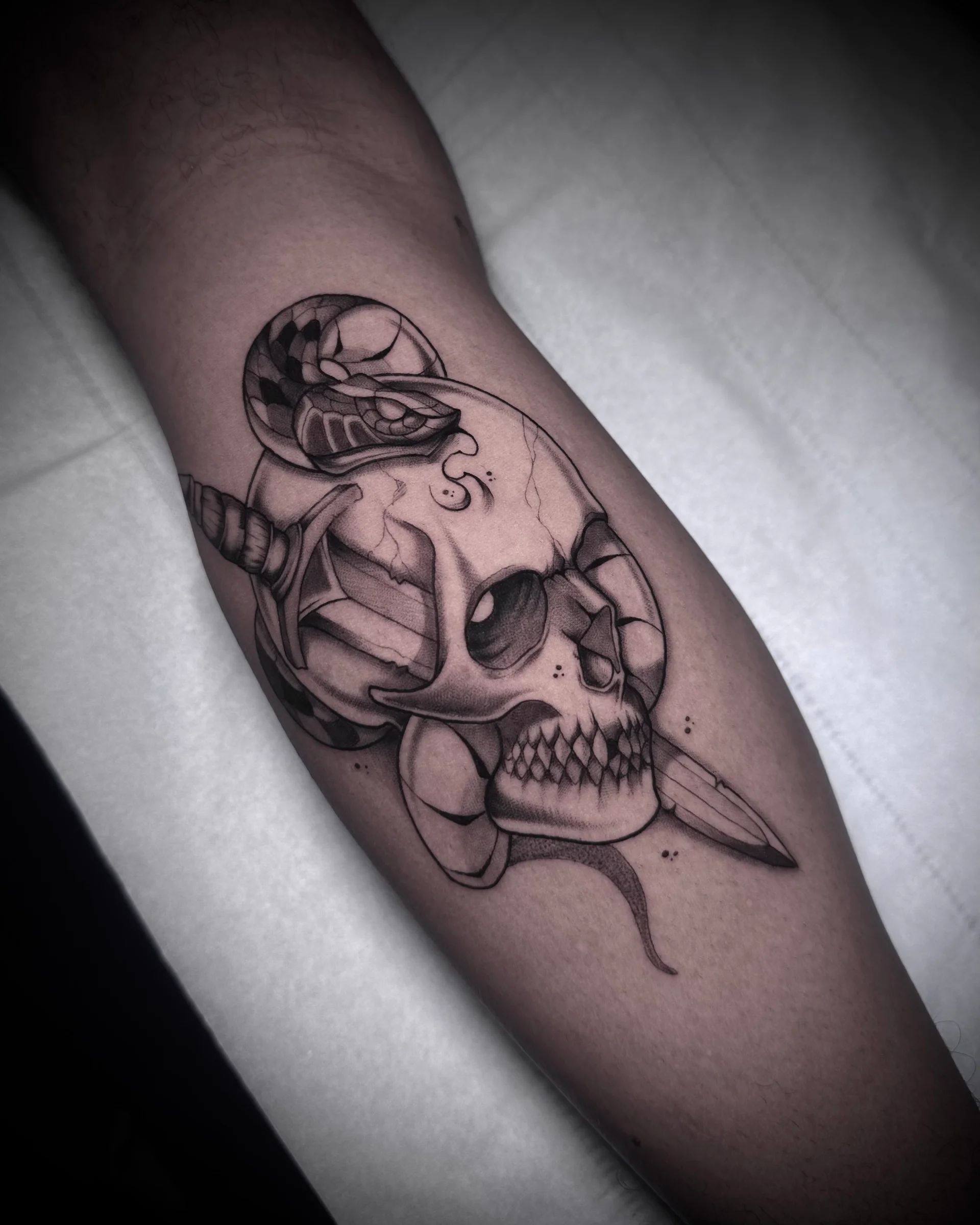 Calavera con daga y serpiente en el antebrazo