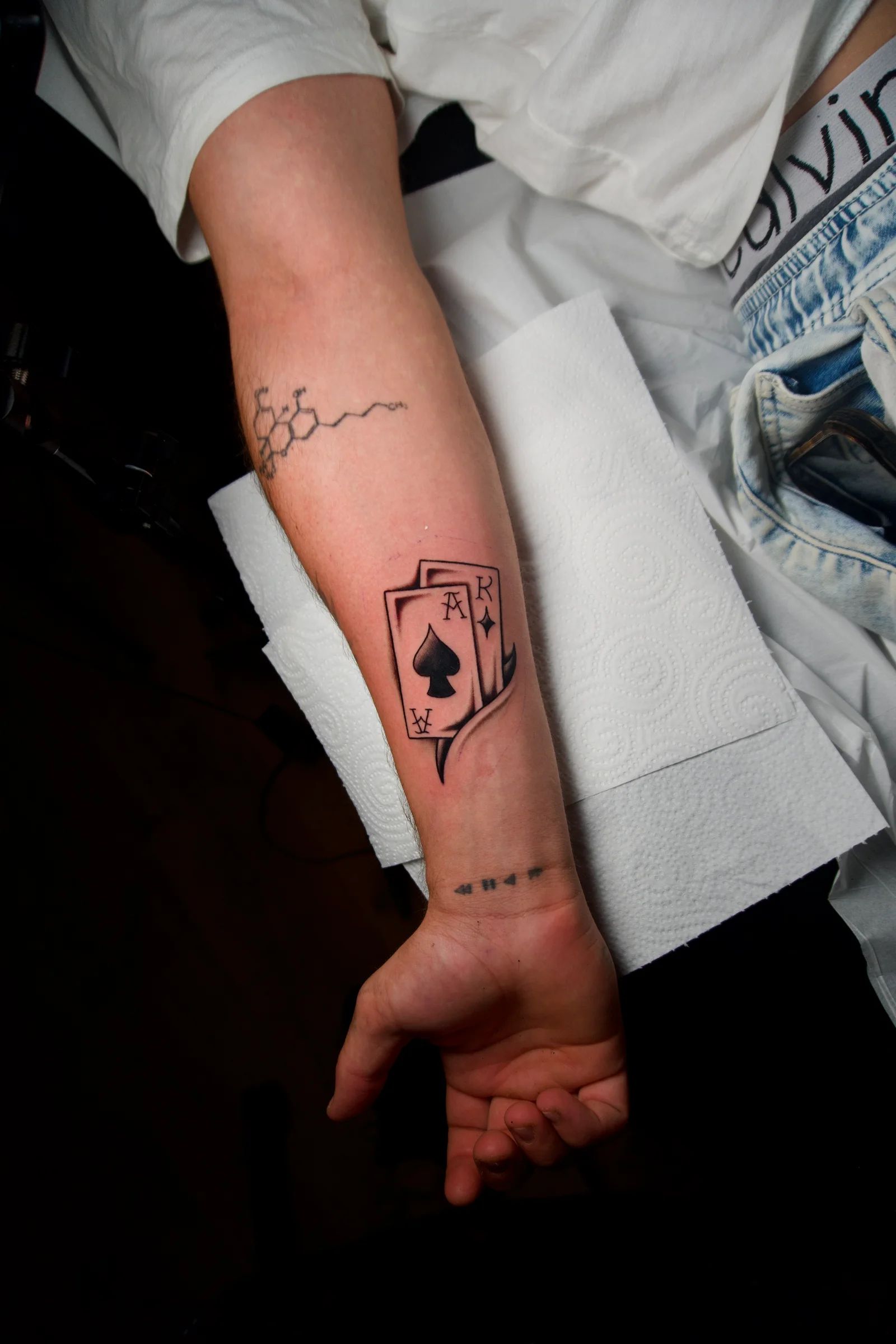 Cartas de póker con el as de picas en el antebrazo