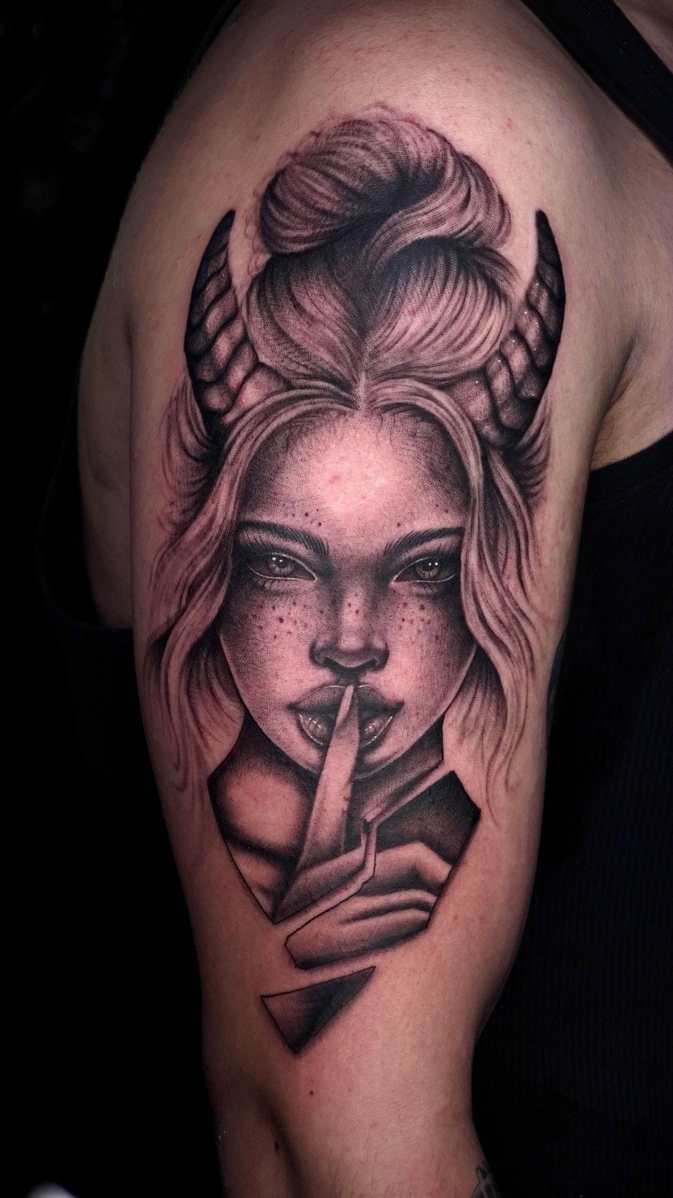 Mujer con cuernos que pide silencio, en el brazo