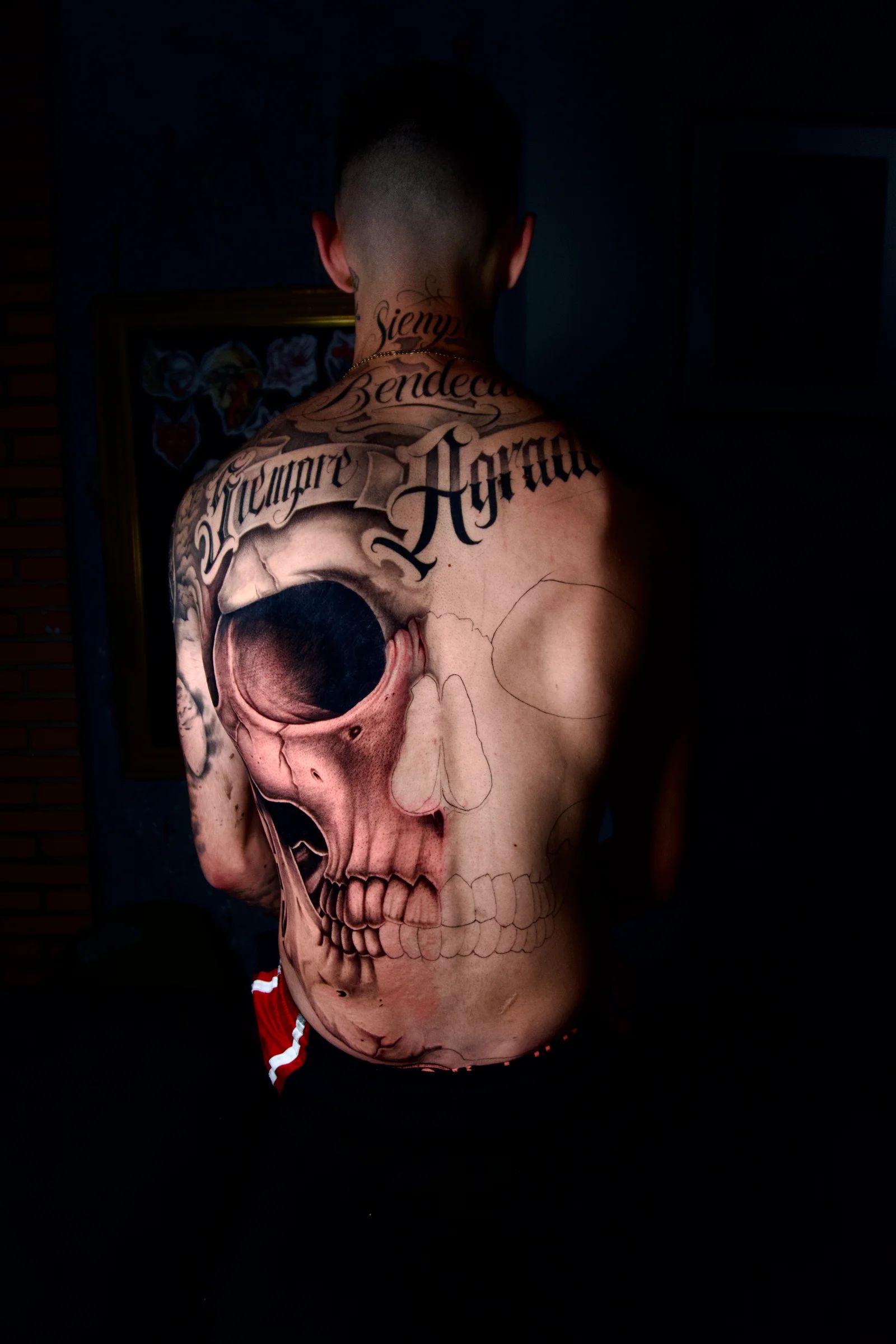 Calavera en toda la espalda, con letras encima